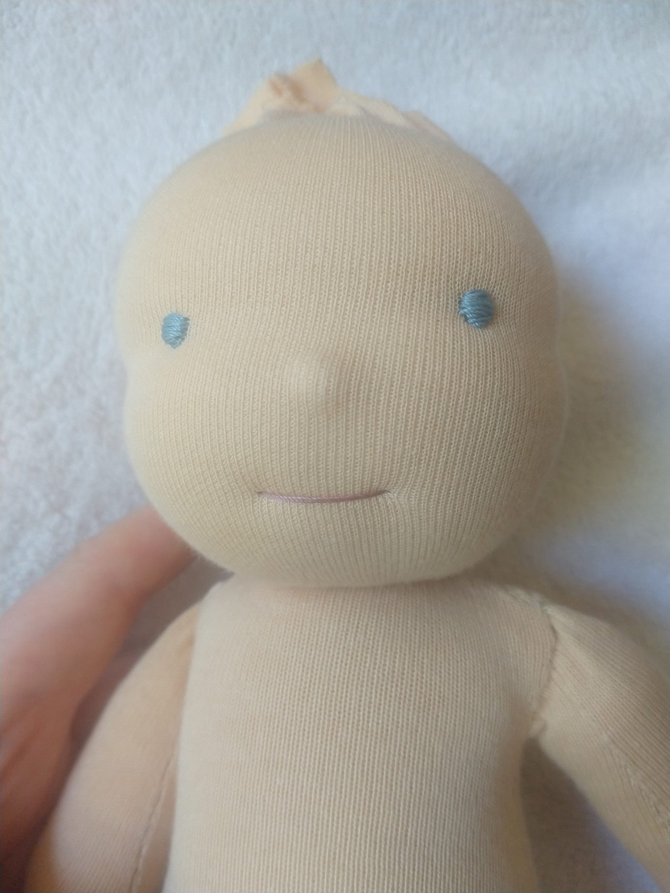 Puppe im Fertigungsprozess, die gerade ein Gesicht bekommen hat, der aber noch die Haare fehlen